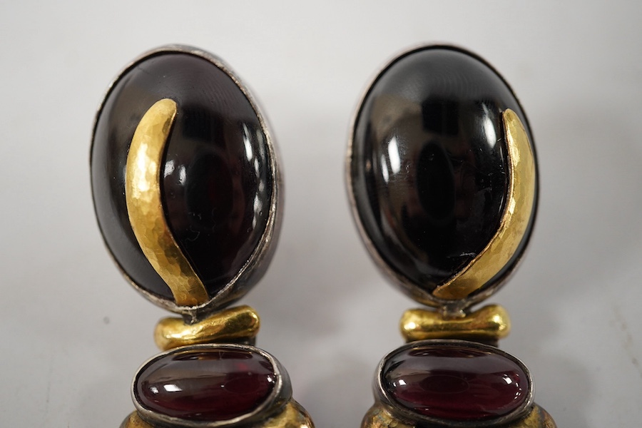 A pair of modern yellow and white metal mounted three stone oval cabochon garnet set drop earrings, by Elaine Coyne, signed, 51mm, gross weight 28.2 grams. Condition - fair